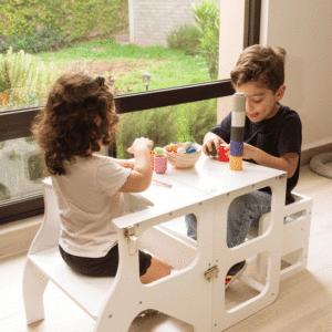 Niños en mesa montessori, torre de aprendizaje convertible